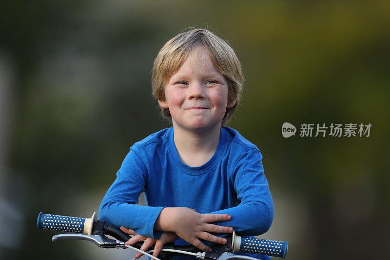 一个小男孩在附近骑自行车。