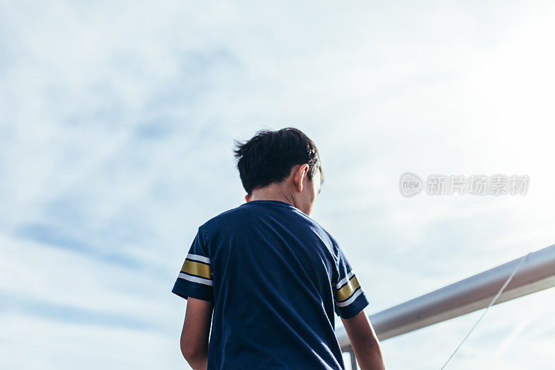 年轻的亚洲男孩在码头上钓鱼
