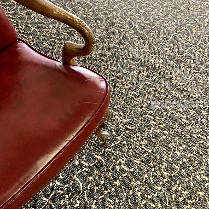 地毯上的旧皮椅子