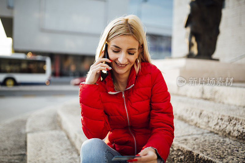 年轻的白种金发女人在用智能手机打电话