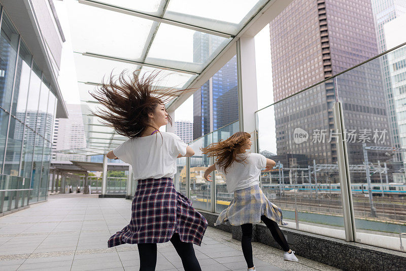 年轻的女性朋友在城市里跳舞