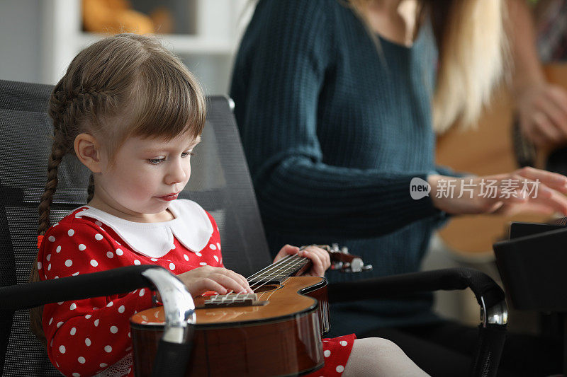 无聊的女孩抱着吉他，玩弄乐器