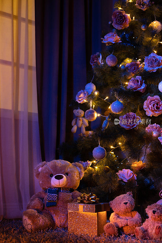 泰迪熊在客厅的一棵大圣诞树下。
