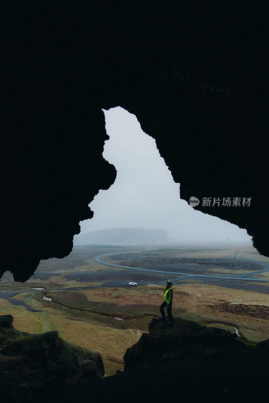 一个女人的剪影从洞穴里看冰岛的风景