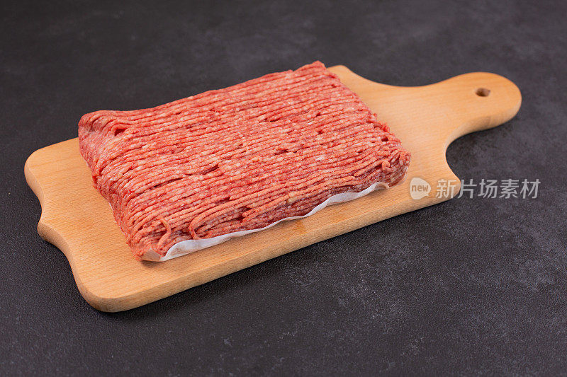 新鲜的生牛肉末，猪肉末，放在背纸和砧板上