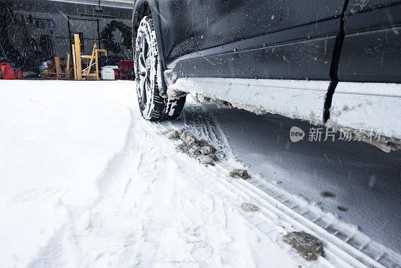 开放车库车道冬季雪车轮胎痕迹