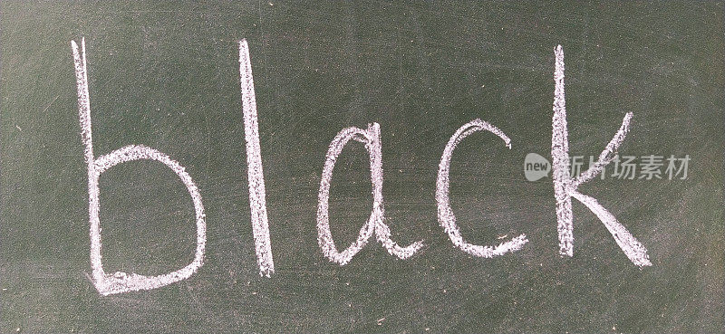 “BLACK”这个词用手写在绿色的学校黑板上。黑色的颜色。打印信件