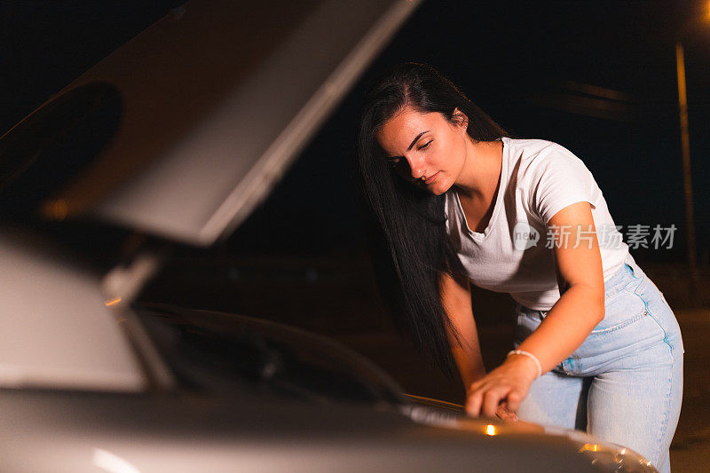 一位年轻女子在路边修汽车