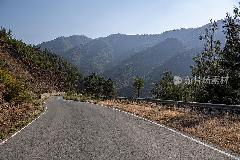 道路环抱着平缓蜿蜒的山坡，穿过陡峭的火山地形，在傍晚的灯光下朦胧的群山