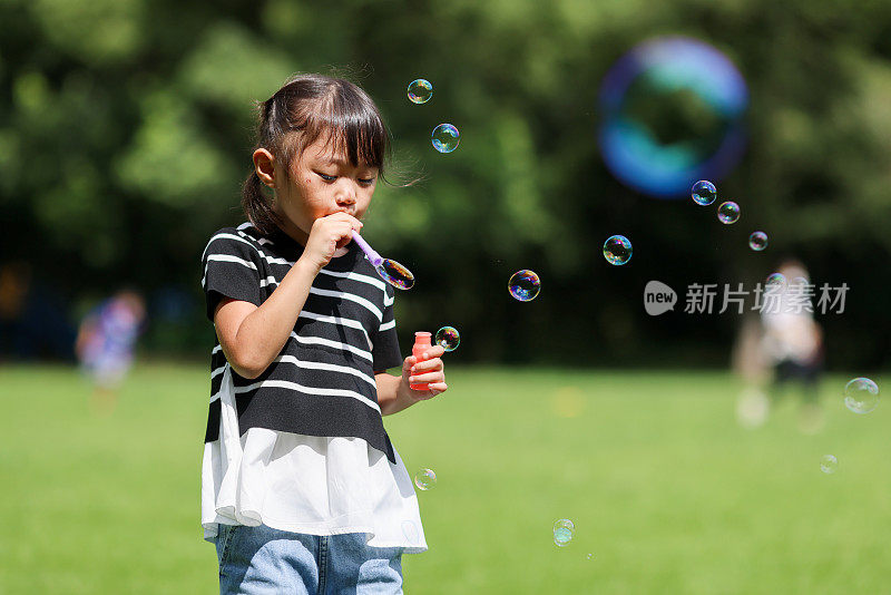 妈妈和女儿在公园里玩肥皂泡