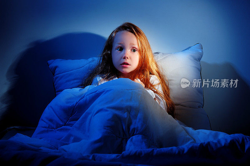 睡不着，害怕的小女孩坐在床上