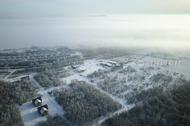 在寒冷的冬天，乡村郊区城镇地区，屋顶被雪覆盖的私人住宅的鸟瞰图