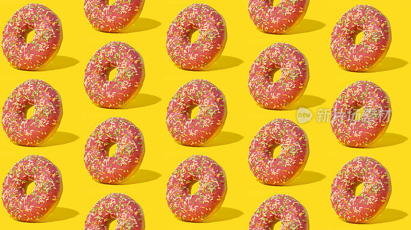 粉红色釉面甜甜圈在黄色背景上的图案