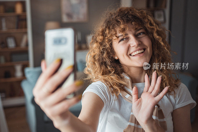 一个美丽的年轻女子正在她的公寓里用手机享受早晨