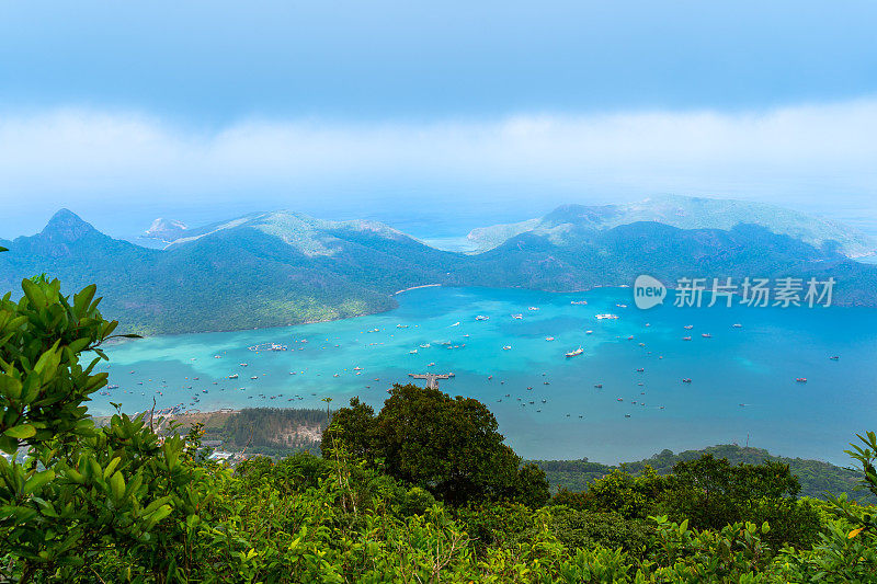 越南孔岛本丹港，湛蓝的大海，蓝天山和五颜六色的船只。