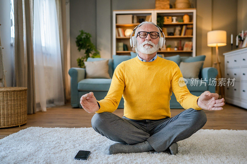 成熟的老年男子在家练习引导冥想的表现