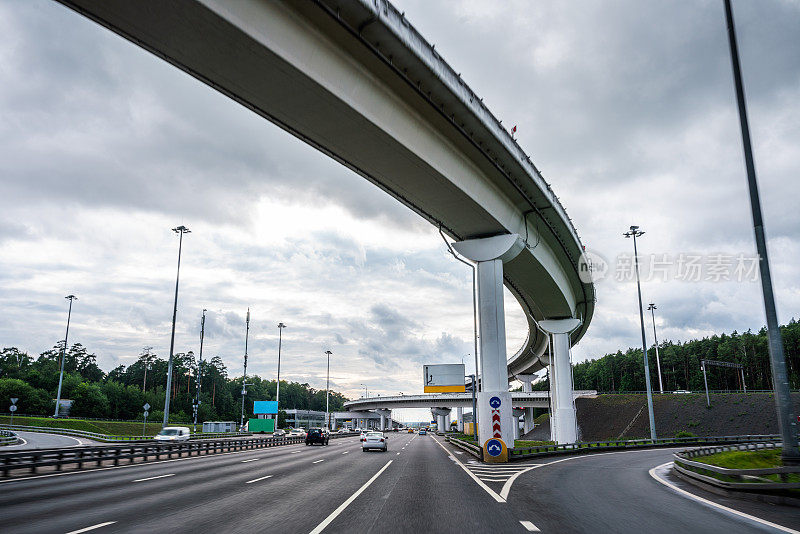 骑行在立交桥下的公路上，多车道高速公路，汽车视角