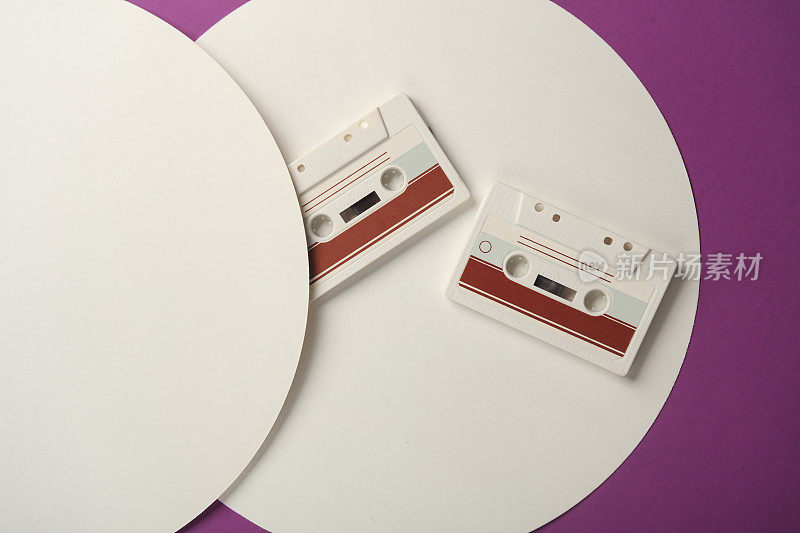 复古的80年代音频磁带在紫色背景与白色圆圈。俯视图