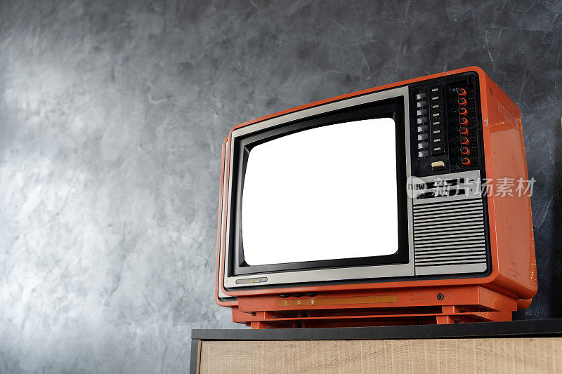 房间里放着一台带有空白屏幕的复古电视。一台旧的橙色电视机关掉了，正在剪辑路径。