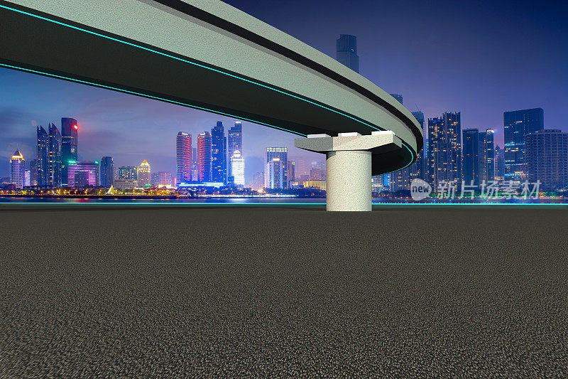 沥青空的空间道路和霓虹桥与现代城市天际线夜间高清照片
