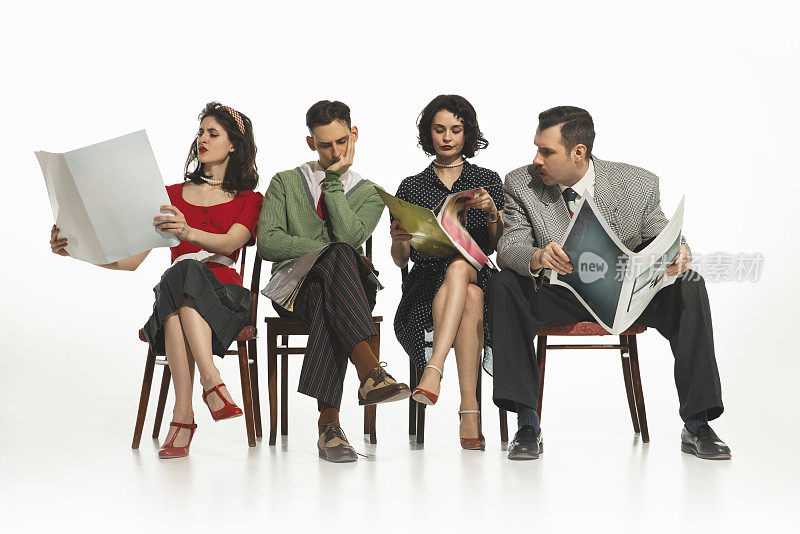一组四个人，男人和女人穿着复古风格的衣服坐在椅子上，阅读报纸，白色背景的杂志。