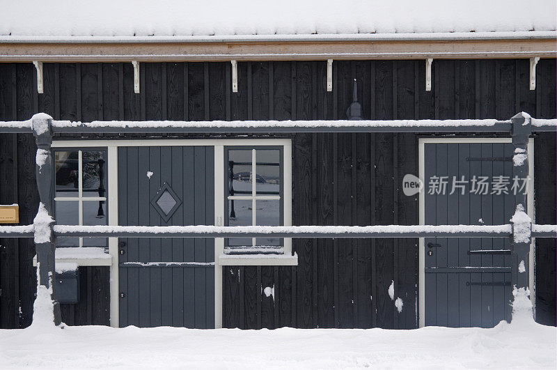 金属栅栏和有雪的房子