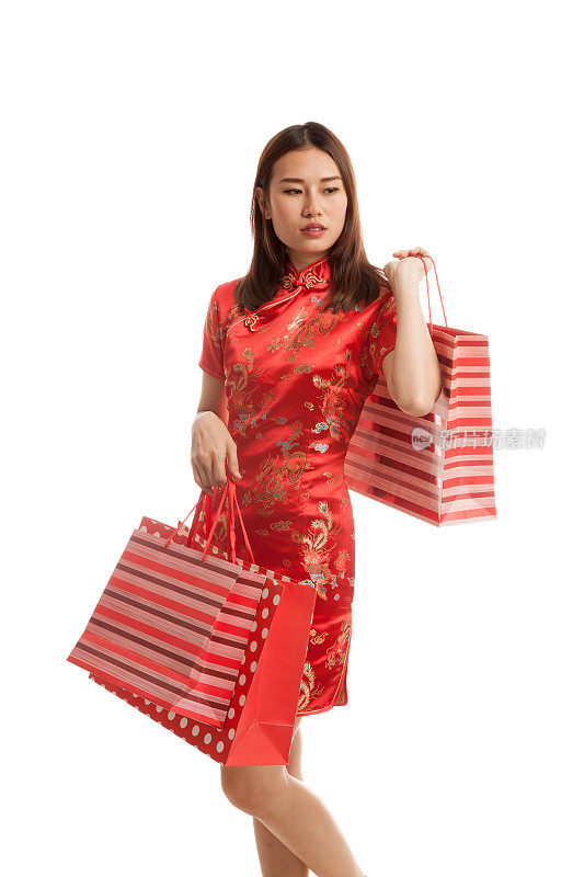亚洲女孩穿着中国旗袍和购物袋。