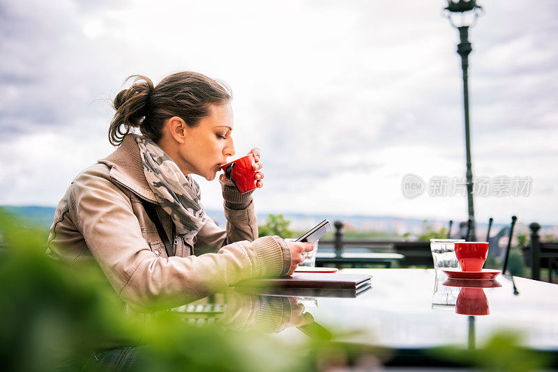 用智能手机喝咖啡的女人