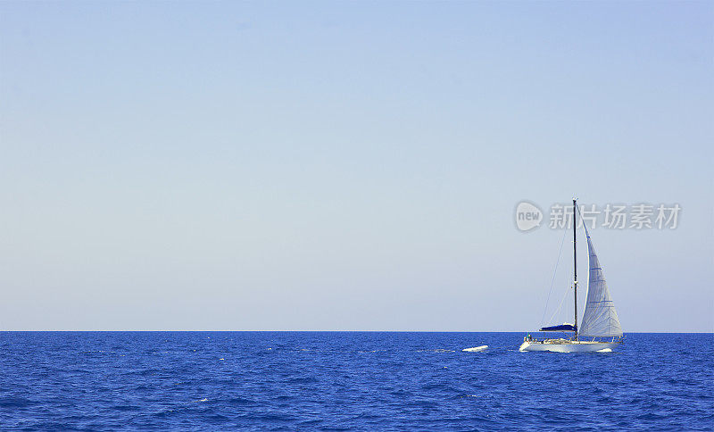 帆船在广阔的蓝色海洋上