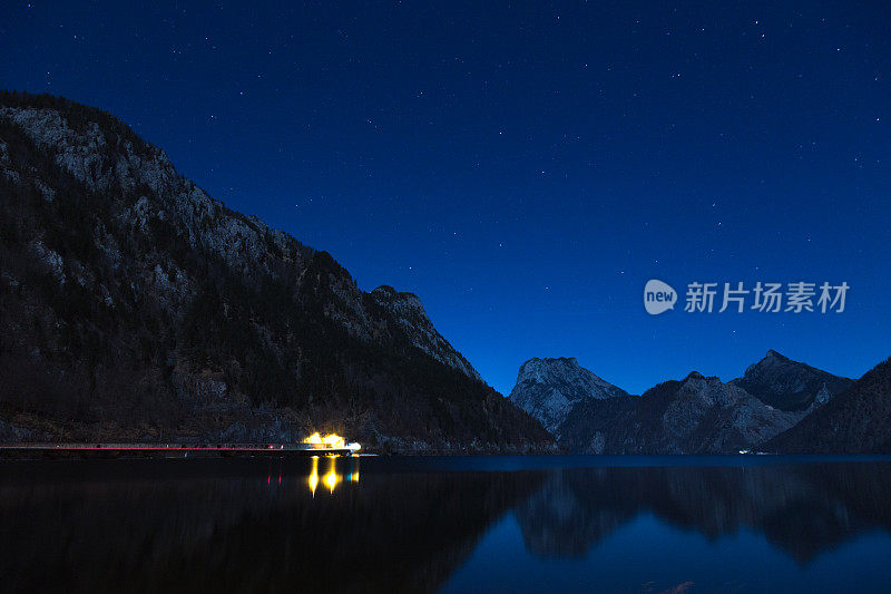 夜晚，车灯在山上和湖里留下痕迹