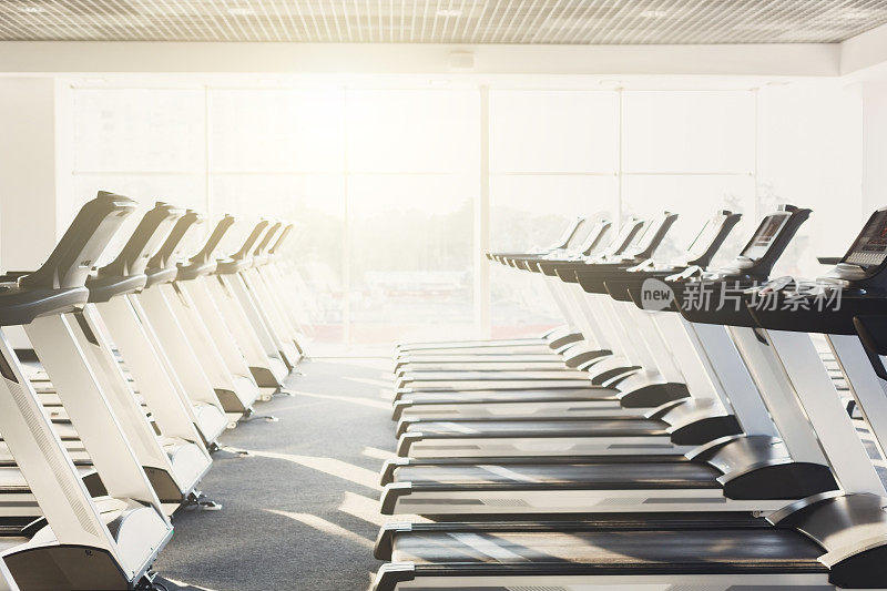 现代化的健身房内部配备设备，跑步机健身有氧训练