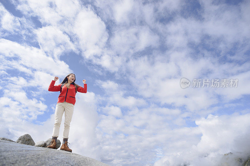 年轻女子庆祝登上山顶