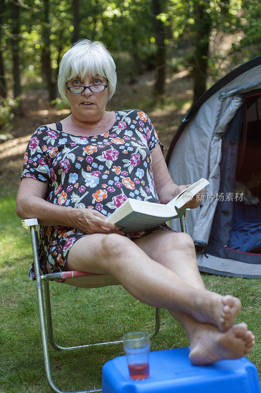 老妇人抬头惊讶地在帐篷里看书
