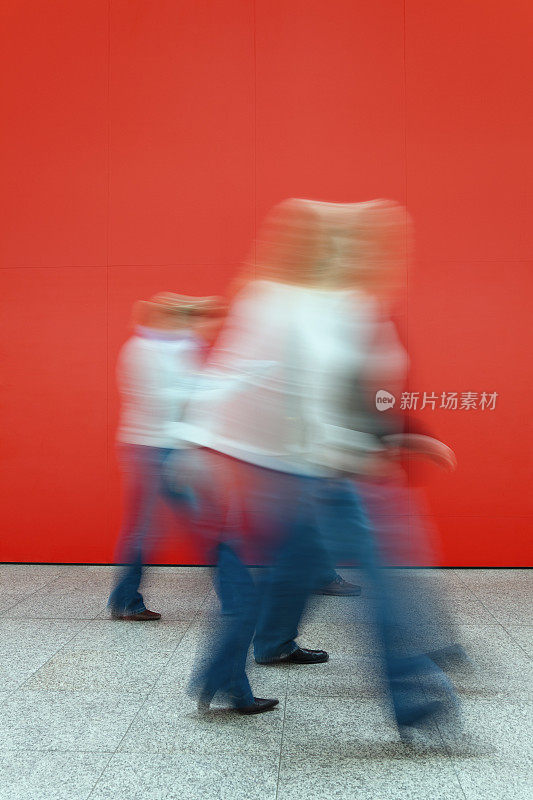 运动模糊的女人走在红墙上