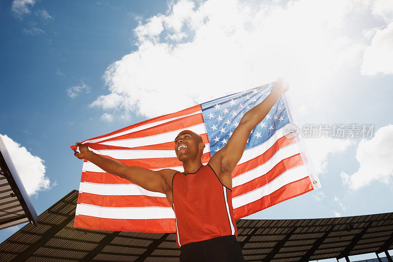男运动员举着美国国旗庆祝胜利