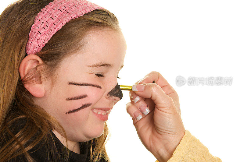 可爱的小女孩有她的脸画成猫