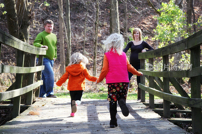 快乐的家庭在公园-孩子们跑到父母过桥