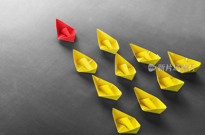 领导理念红色领导纸船从一群黄色小船中脱颖而出