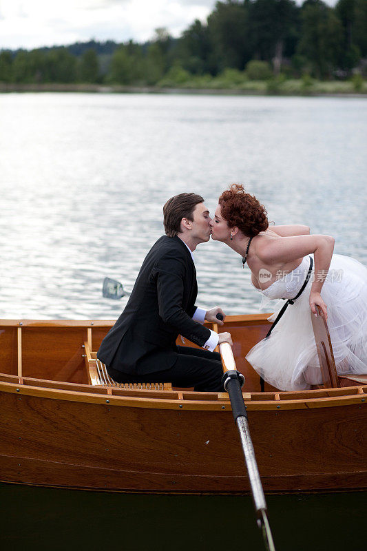 新娘和新郎在木船上接吻