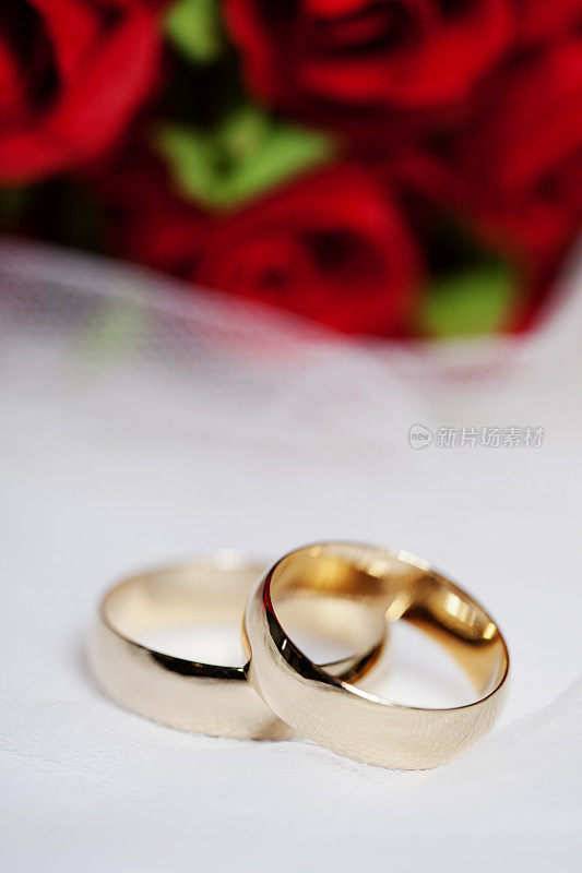 结婚戒指和红玫瑰花束