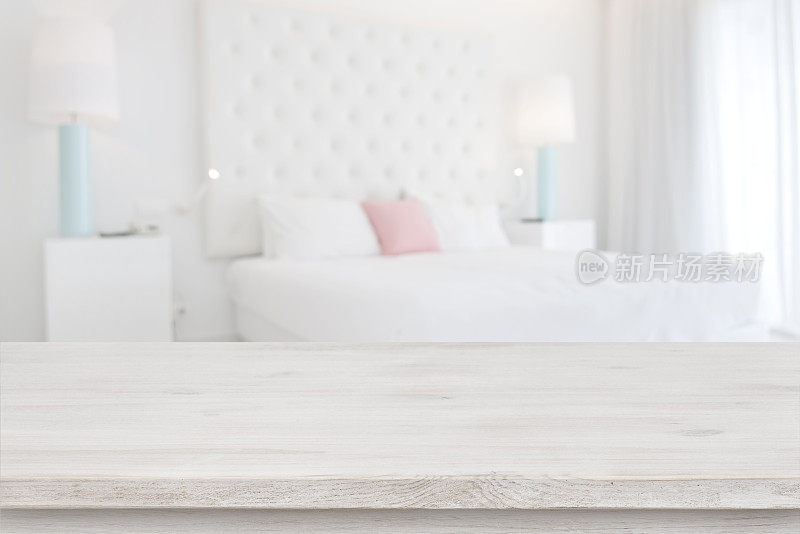 模糊的卧室室内背景前的木制桌面