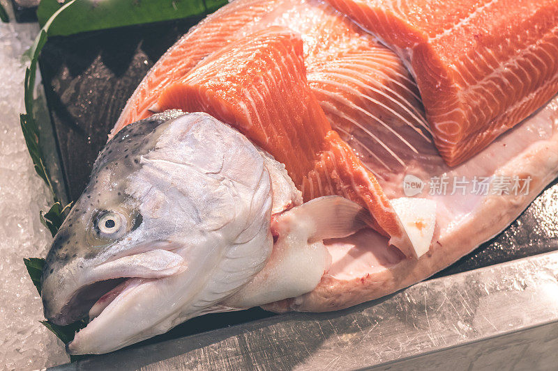 仔细观察生三文鱼片的肉质。印度尼西亚巴厘岛当地食品市场上的生鲑鱼和大西洋鱼