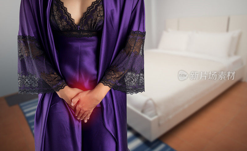 穿紫色缎子睡衣和睡袍的女人起床去洗手间。有膀胱问题的人的概念