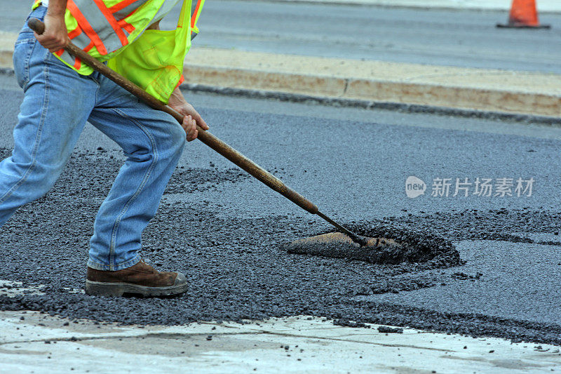 在公路维修现场耙热沥青