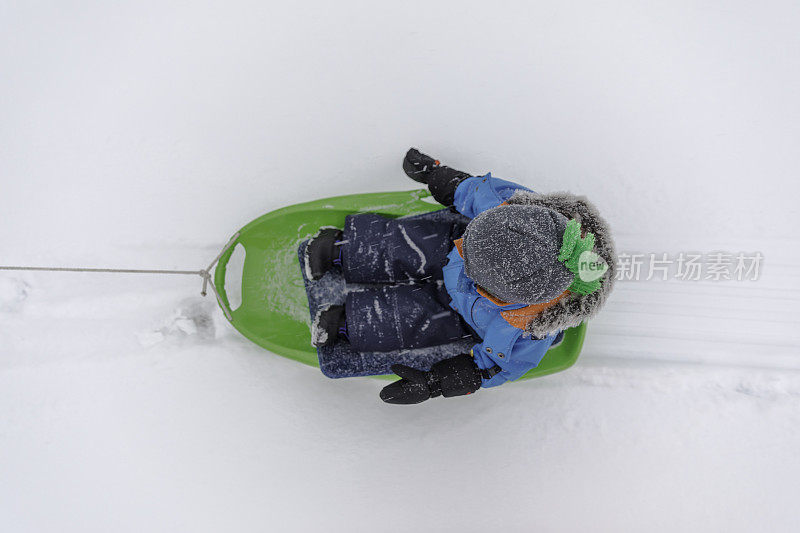 冬天里用雪橇拉着的男婴