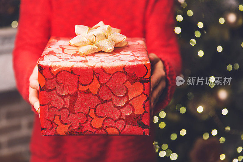 女人的手捧着圣诞或新年装饰的礼品盒。