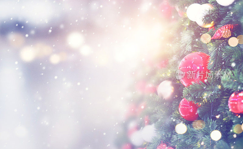 圣诞节的背景。红色的小玩意挂在用白焦和雪装饰的圣诞树上。