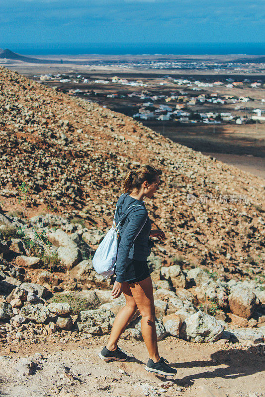 年轻女子徒步旅行与全景火山