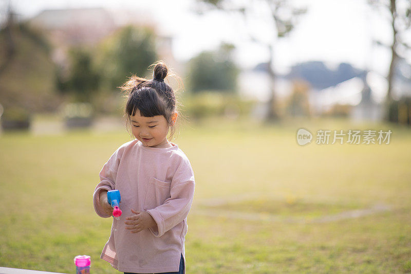 小女孩在公园里玩泡泡