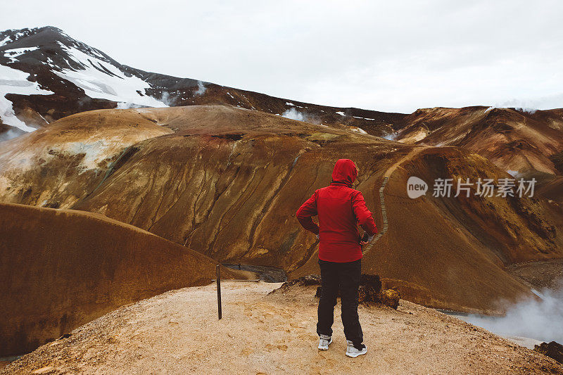 身穿红色夹克的男子在欣赏Kerlingarfj?ll火山景观在冰岛
